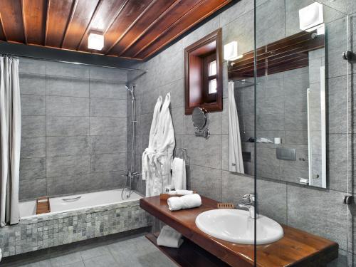 a bathroom with a sink and a bath tub at Aristi Mountain Resort in Aristi