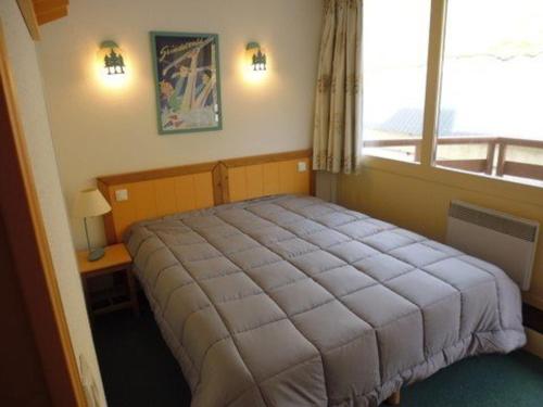 um quarto com uma cama grande e uma janela em Appartement La Mongie, 2 pièces, 6 personnes - FR-1-404-115 em La Mongie