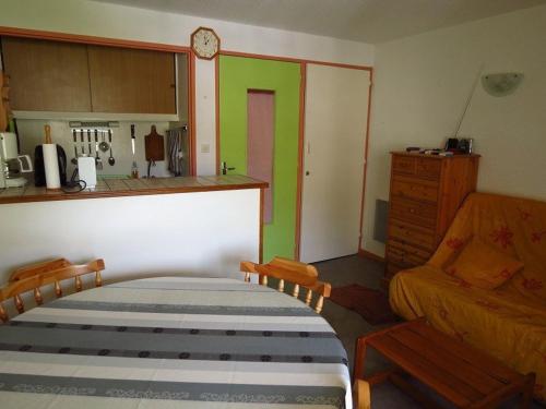 Cet appartement comprend une chambre avec un lit et une cuisine aux murs verts. dans l'établissement Studio cabine 4p, parking couvert, à 50m des pistes - FR-1-404-101, à La Mongie