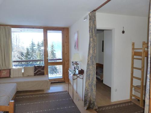 ein Wohnzimmer mit Couch und großem Fenster in der Unterkunft Appartement 2 pièces, 6 pers, centre Arc 1800, prox pistes et commerces, animaux admis - FR-1-411-148 in Arc 1800