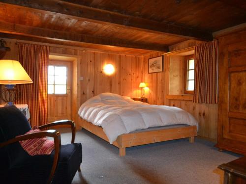 une chambre avec un lit dans une pièce en bois dans l'établissement Ferme rénovée à Notre-Dame-de-Bellecombe, 8 pers, grande terrasse, animaux acceptés, parking - FR-1-505-46, à Notre-Dame-de-Bellecombe