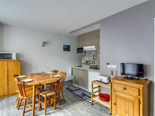 une salle à manger avec une table et une cuisine dans l'établissement Appartement rénové pour 4 pers, 1 chambre, parking, centre de Cauterets, proche télécabine - FR-1-401-84, à Cauterets