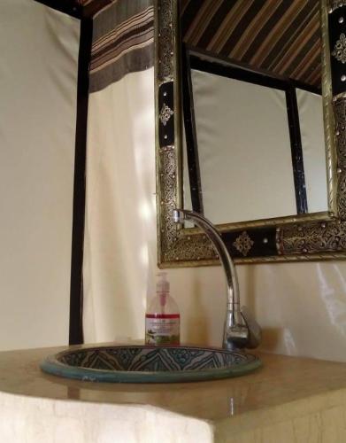 a sink in a bathroom with a mirror and a sink at Luxury Local Camp in Merzouga