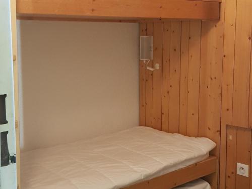 Ce lit superposé se trouve dans un dortoir doté de murs en bois. dans l'établissement Studio confortable, proche des pistes, balcon, animaux admis, WiFi - FR-1-411-215, à Arc 1800