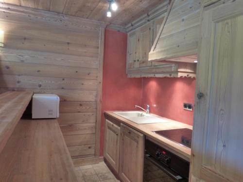 uma cozinha com paredes de madeira, um lavatório e um balcão em Appartement Méribel, 3 pièces, 6 personnes - FR-1-411-68 em Les Allues