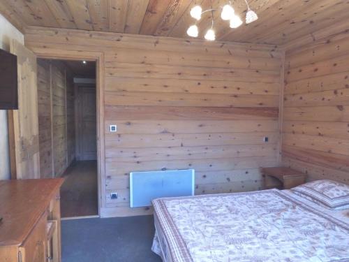 um quarto com uma cama numa parede de madeira em Appartement Méribel, 3 pièces, 6 personnes - FR-1-411-68 em Les Allues