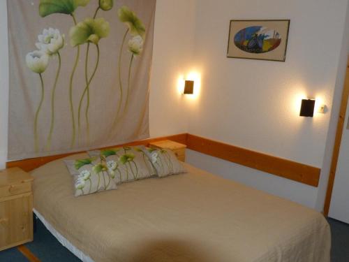 une chambre avec un lit avec des fleurs peintes sur le mur dans l'établissement Appartement Duplex 2P 6 Pers. Skis aux Pieds, Village de Charmettoger, Arc 1800 - FR-1-411-219, à Arc 1800