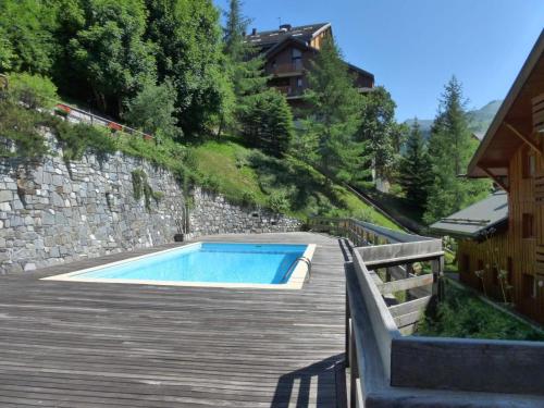 - une piscine sur une terrasse en bois à côté d'un bâtiment dans l'établissement Charmant Duplex 4P avec Terrasse, Piscine et Garage - Méribel Centre, 8 Pers. - FR-1-411-71, à Les Allues