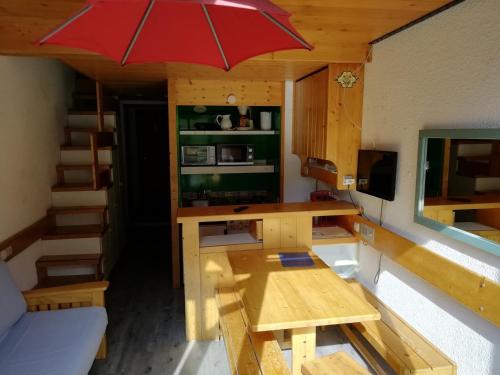 Cette petite chambre dispose d'une table et d'un bureau avec un parasol. dans l'établissement Duplex cosy 5 pers. avec balcon Sud, proche pistes et commodités - Arc 1800 - FR-1-411-238, à Arc 1800