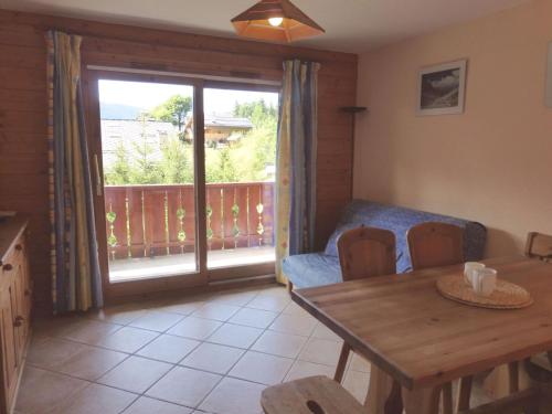 d'un salon avec une table et un balcon. dans l'établissement Appartement cosy 3 pièces pour 4 personnes à Méribel Village, proche des pistes et commerces - FR-1-411-256, à Les Allues
