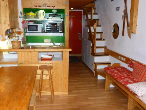 une cuisine avec une table et une cuisine avec un escalier dans l'établissement Charmettoger Arc 1800 : Duplex 5 pers, Balcon Sud, Proche Pistes et Commodités - FR-1-411-286, à Arc 1800
