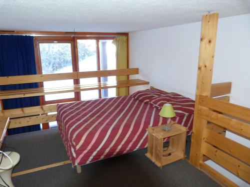 - une chambre avec des lits superposés et une table avec une lampe dans l'établissement Duplex pour 5 pers. - Ski aux pieds, Balcon, WiFi, Animaux OK, Arc 1800 - FR-1-411-287, à Arc 1800