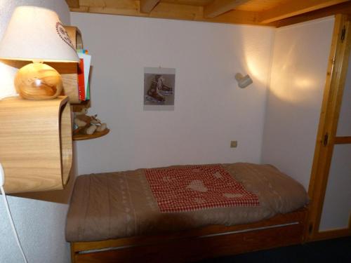 - une petite chambre avec un lit et une lampe dans l'établissement Duplex 2 pièces avec balcon et WiFi à Arc 1800, proche des pistes - FR-1-411-132, à Arc 1800