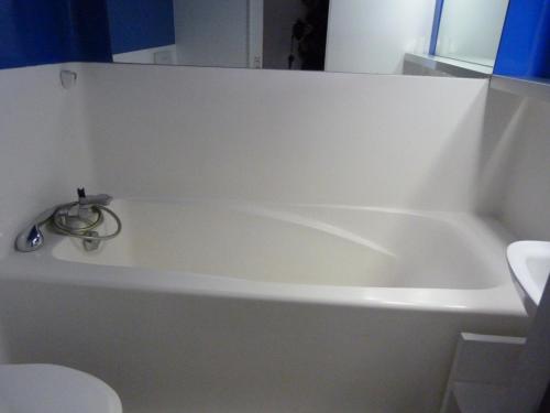 La salle de bains est pourvue d'une baignoire blanche et de toilettes. dans l'établissement Charmant duplex classé 3 cristaux, 6 pers, proche pistes, balcons Nord-Sud, Arc 1800 - FR-1-411-179, à Arc 1800