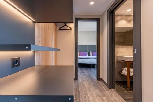 a kitchen with a counter and a room with a bed at Astari in Tarragona