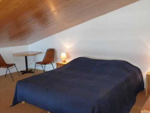 une chambre avec un lit bleu et deux chaises dans l'établissement Appartement Duplex 52m², 7 pers, proche pistes/commerces, animaux admis, parking, Wi-Fi - FR-1-411-195, à Arc 1800