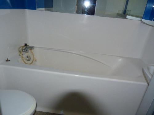 La salle de bains est pourvue d'une baignoire blanche et de toilettes. dans l'établissement Appartement 5 personnes proche pistes à Arc 1800, village de Charmettoger - FR-1-411-209, à Arc 1800