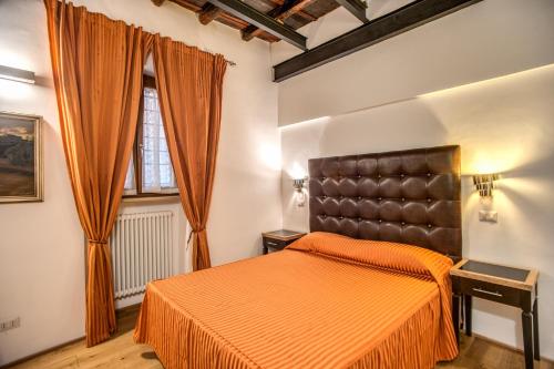 ein Schlafzimmer mit einem orangenen Bett und einem Fenster in der Unterkunft Casa Leonetto in Rom