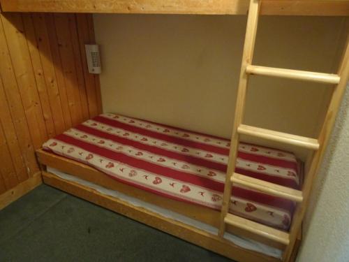 a bunk bed with a ladder in a room at Studio Les Arcs 1800, 1 pièce, 5 personnes - FR-1-411-374 in Arc 1800