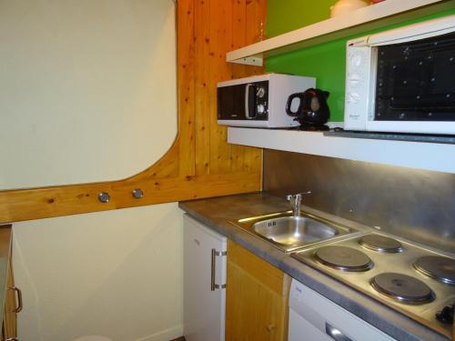 une petite cuisine avec un évier et un micro-ondes dans l'établissement Studio 5 personnes aux Arcs 1800, skis aux pieds, proche commerces, balcon, animaux acceptés. - FR-1-411-374, à Arc 1800