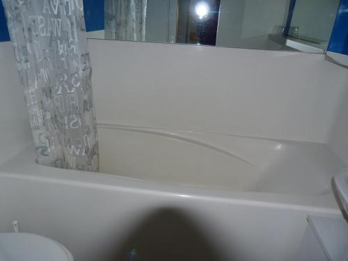 La salle de bains est pourvue d'une baignoire blanche et d'un miroir. dans l'établissement Appartement Les Arcs 1800, 1 pièce, 5 personnes - FR-1-411-250, à Arc 1800