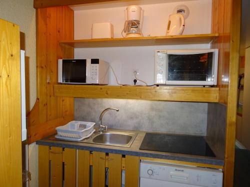une cuisine avec un évier et un micro-ondes dans l'établissement Spacieux Duplex 4P/9 Pers, Terrasse Sud-Ouest, Proche Pistes et Commerces - Arc 1800 - FR-1-411-210, à Arc 1800