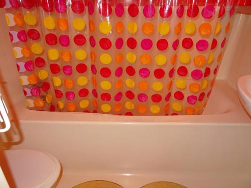 La salle de bains est pourvue d'un rideau de douche avec des boutons colorés. dans l'établissement Spacieux Duplex 4P/9 Pers, Terrasse Sud-Ouest, Proche Pistes et Commerces - Arc 1800 - FR-1-411-210, à Arc 1800