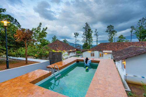 a man standing in a swimming pool in a house at Zostel Plus Wayanad in Kalpetta