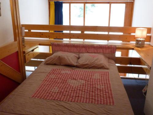 une chambre avec un lit avec une tête de lit en bois dans l'établissement Duplex 2 pièces 5 pers, balcon sud, proche pistes et commerces, Animaux admis - Arc 1800 - FR-1-411-296, à Arc 1800