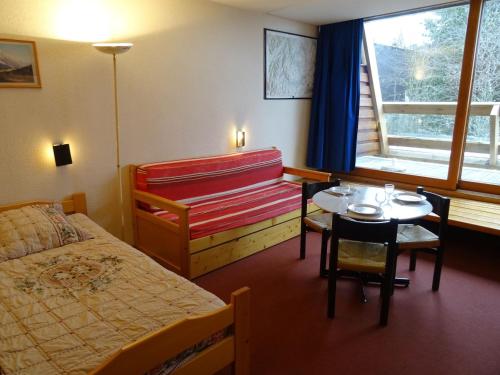une chambre d'hôtel avec un lit, une table et une fenêtre dans l'établissement Studio cosy 3 pers à Arc 1600 - Ski aux pieds, proche commerces, balcon Sud, parking et Wifi inclus - FR-1-411-421, à Arc 1600