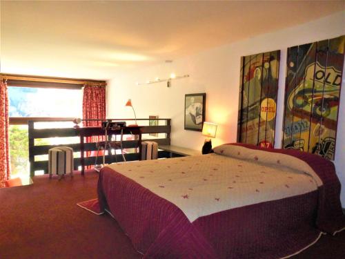 a bedroom with a bed and a table and a window at Studio Méribel, 1 pièce, 4 personnes - FR-1-411-435 in Les Allues