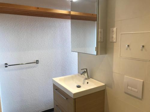 une salle de bain blanche avec un lavabo et un miroir dans l'établissement Appartement 3 pièces pour 7 personnes à Arc 1600, ski aux pieds, proche commerces, WiFi - FR-1-411-325, à Arc 1600