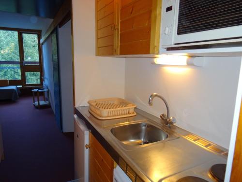 une cuisine avec un évier et un plan de travail dans l'établissement Studio 4 pers, proche pistes et commerces, cœur village Charvet, Arcs 1800 - FR-1-411-321, à Arc 1800