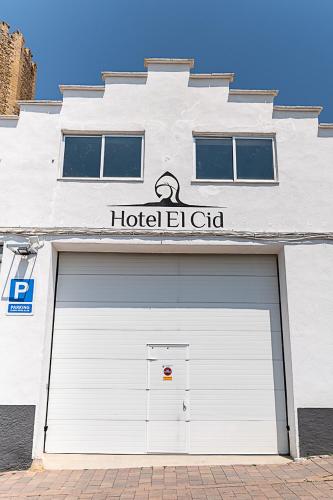 a white building with ajar garage door with a hoteligiligiligiligiligil at Hotel El Cid in Morella