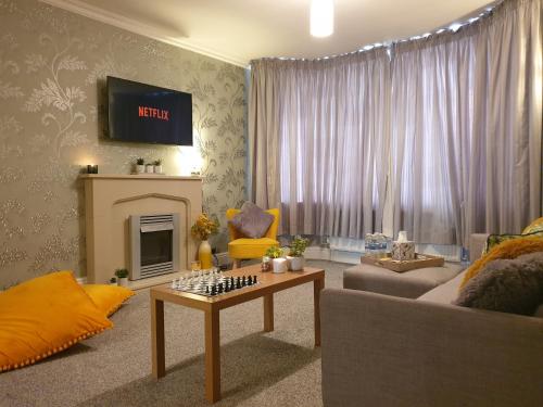 uma sala de estar com um sofá e uma mesa em Spacious City Home with Free Parking, Fast Wi-Fi & Netflix em Coventry