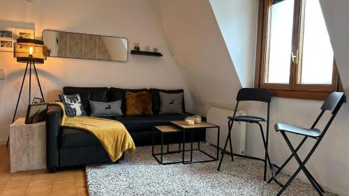 uma sala de estar com um sofá preto e cadeiras em Estudio a pie de Pistas Baqueira em Baqueira-Beret