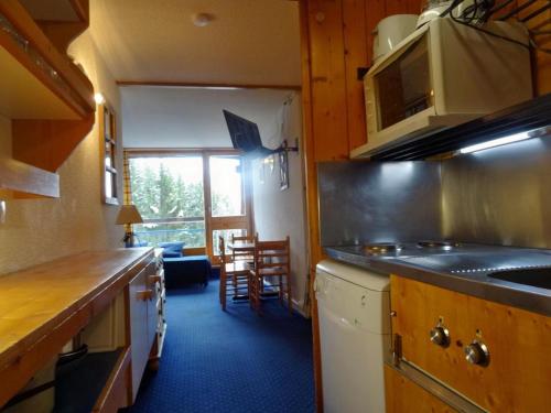 une cuisine avec un évier et une cuisinière four supérieur dans l'établissement Studio skis aux pieds pour 4 pers, balcon, animaux admis - FR-1-411-389, à Arc 1800