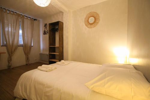 ein Schlafzimmer mit einem weißen Bett und Handtüchern darauf in der Unterkunft Le patio de Théo - proche gare - centre-ville in Angoulême