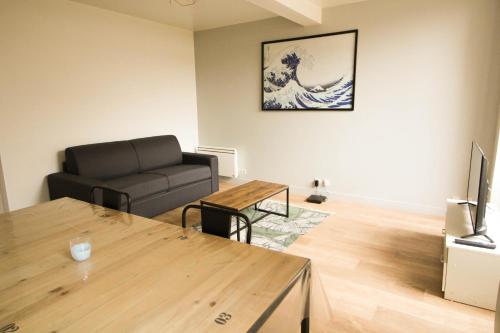 un salon avec un canapé et une table dans l'établissement Le patio de Théo - proche gare - centre-ville, à Angoulême