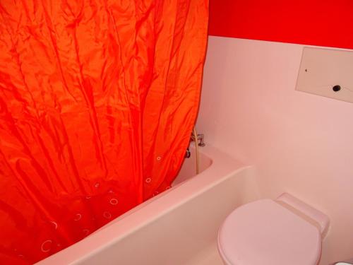 - un rideau de douche orange dans la salle de bains pourvue de toilettes dans l'établissement Studio skis aux pieds, balcon, animaux admis, 5 pers, Arc 1800 - FR-1-411-429, à Arc 1800