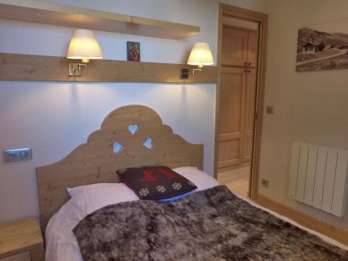 une chambre avec un lit avec une tête de lit en bois dans l'établissement Appartement rénové 2 pièces à Méribel, vue montagne - FR-1-411-517, à Les Allues