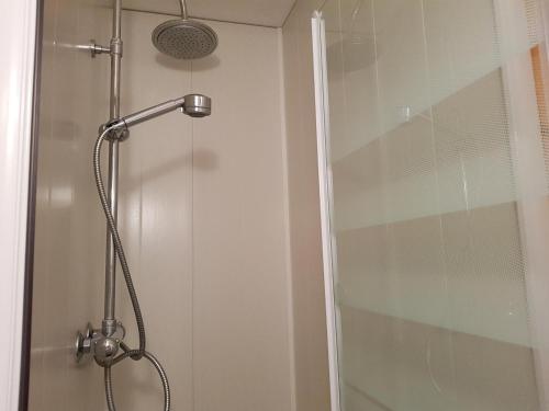 une douche avec une porte vitrée dans une salle de bain dans l'établissement Studio cosy pour 2 à Arc 1600, ski aux pieds, proche commerces et remontées mécaniques - FR-1-411-446, à Arc 1600