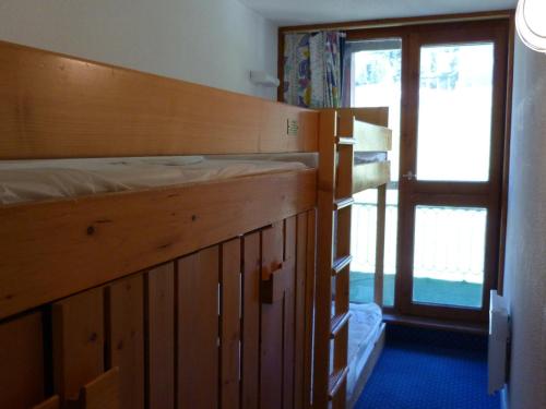 Ce lit superposé se trouve dans un dortoir doté d'une fenêtre. dans l'établissement Appartement 2 pièces, 5 pers, skis aux pieds, proche ESF et garderie - FR-1-411-453, à Arc 1800