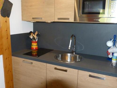 un comptoir de cuisine avec un évier et un micro-ondes dans l'établissement Appartement 2 pièces, 5 pers, skis aux pieds, proche ESF et garderie - FR-1-411-453, à Arc 1800