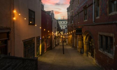 an empty street at night with lights on buildings at Clayton Hotel Bristol City in Bristol