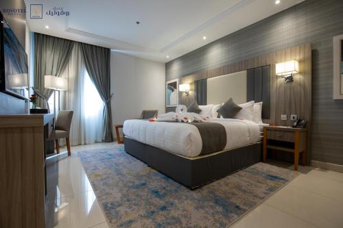 a bedroom with a large bed and a desk at Romera Hotel in Jeddah