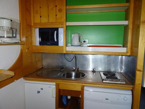une petite cuisine avec un évier et un micro-ondes dans l'établissement Studio skis aux pieds, 5 personnes, balcon, proche commerces, Arc 1800 - FR-1-411-448, à Bourg-Saint-Maurice