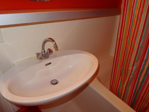 La salle de bains est pourvue d'un lavabo blanc et d'une douche. dans l'établissement Studio skis aux pieds, 5 personnes, balcon, proche commerces, Arc 1800 - FR-1-411-448, à Bourg-Saint-Maurice
