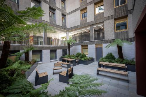 a courtyard of a building with benches and plants at Clayton Hotel Bristol City in Bristol
