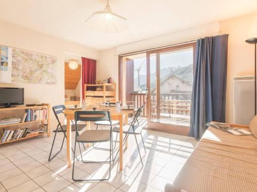 un salon avec une table et des chaises et une fenêtre dans l'établissement Appartement fonctionnel 2 pièces avec parking, centre Briançon - FR-1-330C-60, à Briançon